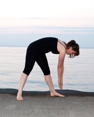 Güneş doğarken genç aktif kadın germe yapmak egzersizleri