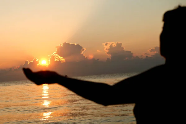 Silhueta humana aberta mãos vazias com palmas para cima sobre o sol — Fotografia de Stock