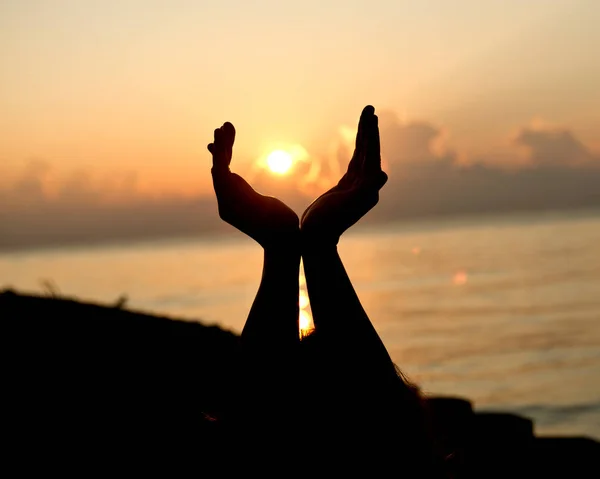 Silhouette human open empty hands with palms up over sun — Stock Photo, Image