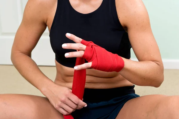Genç aktif kadın kırmızı bandajı teyp elleriyle kaydırma egzersizleri için hazırlanan — Stok fotoğraf