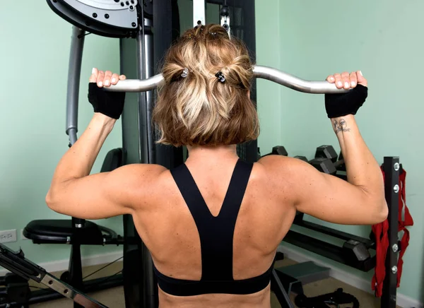 活跃的年轻女子和她的肩膀、 背部和肱三头肌的锻炼 — 图库照片