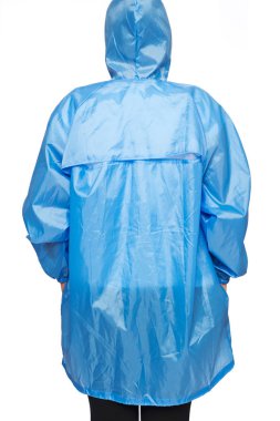 Genç kadın ile beyaz arka plan üzerinde izole kukuleta mavi yağmurluk giyiyor