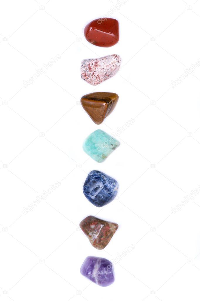 Set of seven healing chakra stones for crystal healing, isolated on white background 