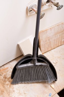 Kepçe ve banyo yenileme sırasında duvara yaslanmış süpürge