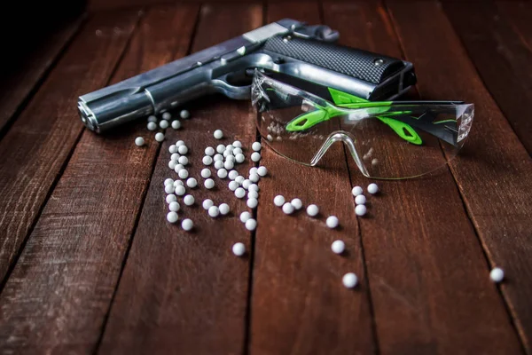 Airsoft gözlük ahşap arka plan üzerinde beyaz toplar
