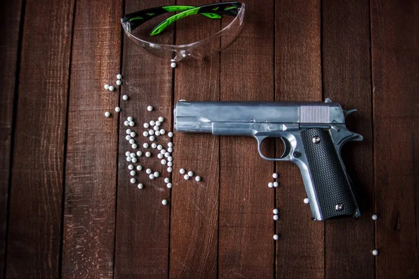 ahşap bir arka plan üzerinde silah yatıyor, airsoft