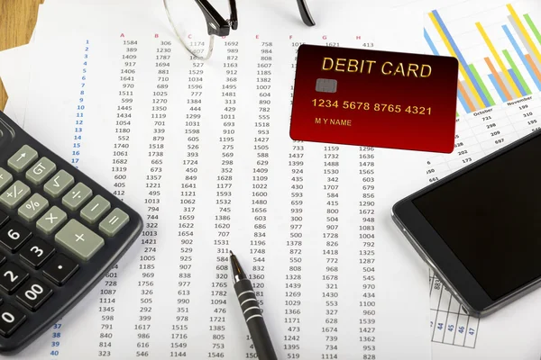 Debit card on a spread sheet with a calculator — Stock Photo, Image