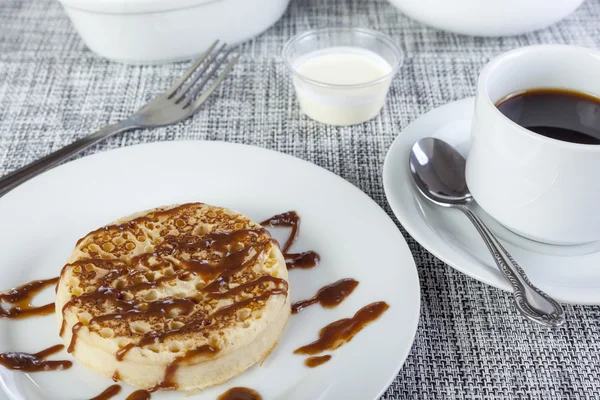 Sticky chocolate sauce on a freshly toasted crumpet with coffee — Stock Photo, Image