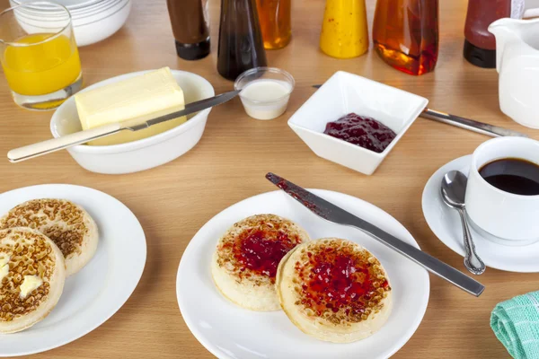 Cormpetas cubiertas de mermelada en una mesa de desayuno ocupada — Foto de Stock