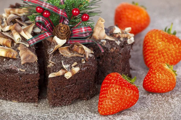 Pastel de Navidad de chocolate esmerilado en rodajas con fresa entera fresca — Foto de Stock