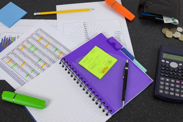 Financial workers desk showing a spreadsheet and graphs