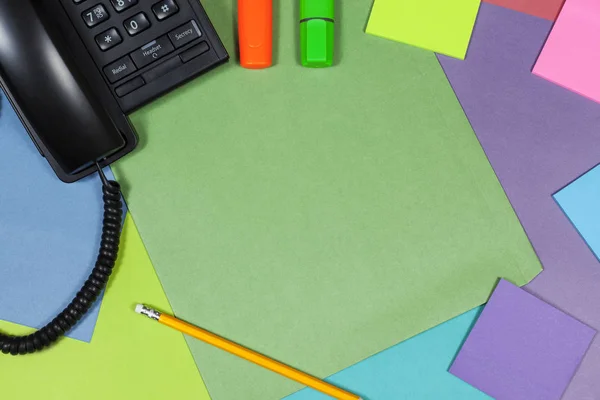 Colourful desktop with a telephone and highlighter pens — Stock Photo, Image