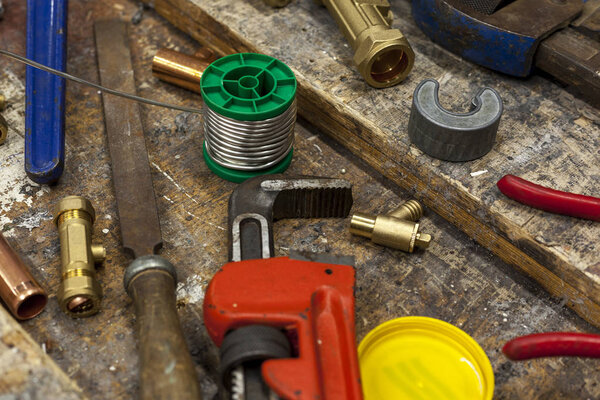 Adjustable wrench and plumbing fittings on a work bench