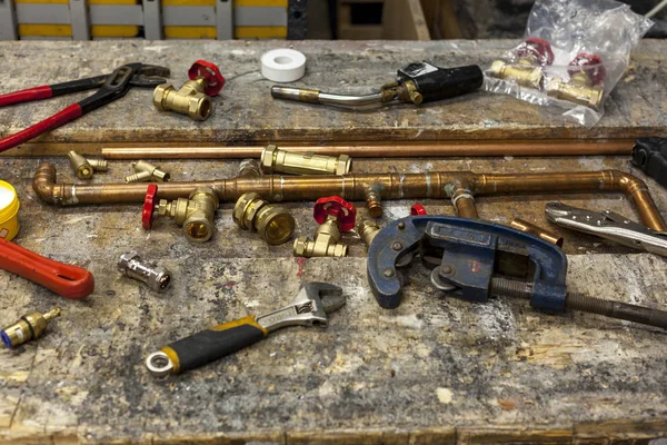 Various plumbing tools and fittings on a workbench