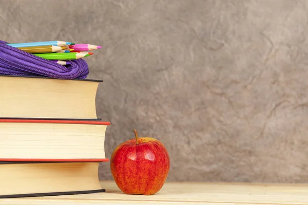 Pencil case on a pile of books with an apple — Stock Photo, Image