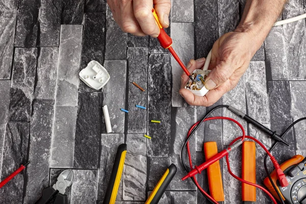 Electrical engineer using a screwdriver to fit a plug — Stock Photo, Image