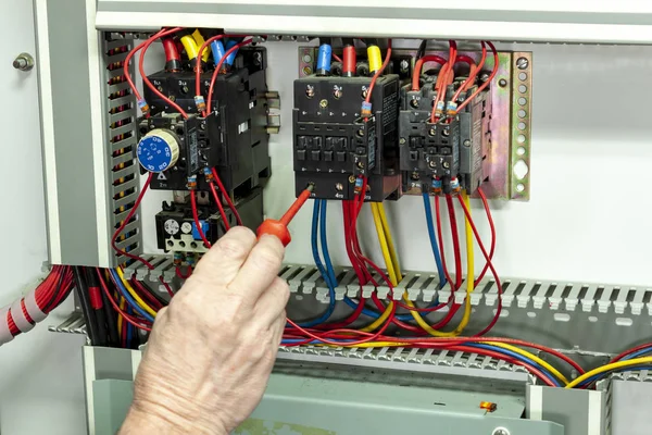 Electricial engineer tightening connections on a contactor — Stock Photo, Image