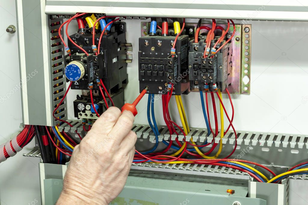 Electricial engineer tightening connections on a contactor