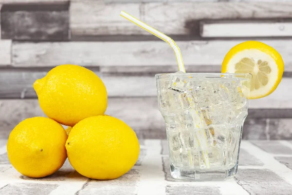 Bir bardak buzlu limonlu su ve biraz da taze limon.