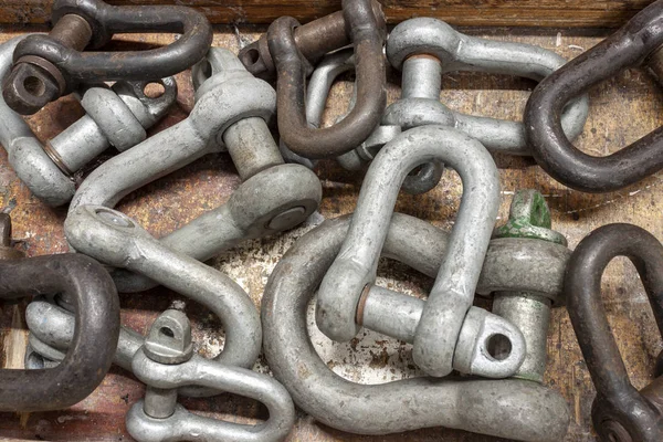 Various sizes of shackles on a workbench Royalty Free Stock Photos