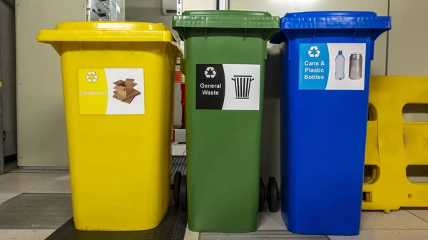 Yellow green and blue recycle wheelie bins in a plant room ストックフォト