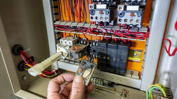 Electrical engineer changing a relay in an old control panel — Stock Photo, Image