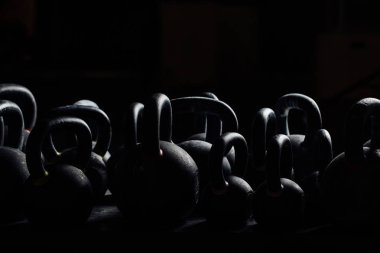 Siluet halter salonunda ağırlık çalışması için. Siyah kettlebells. 24 kg halter.