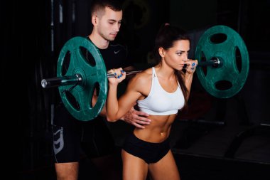 genç kadın ve kişisel antrenör spor salonunda egzersiz.
