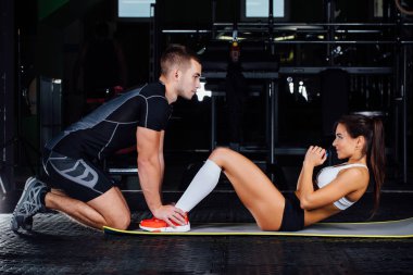 Kadının karın egzersizi basın egzersiz onu spor erkek antrenörü ile mindere yapması.