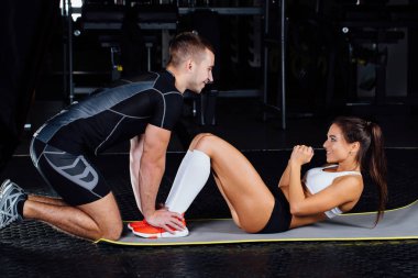 Kadının karın egzersizi basın egzersiz onu spor erkek antrenörü ile mindere yapması.