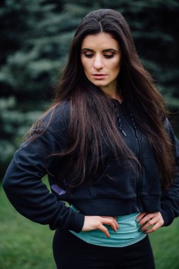 Güzel fitness esmer sporcu kadın Parkı'nda egzersiz dışarı işten sonra poz dinlenme.