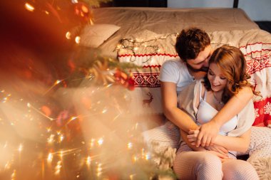 İki yatağın yanında kattaki dinlenme pijama içinde Noel ağacı yakınındaki.