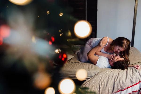 Casal descansando na cama perto da árvore de Natal — Fotografia de Stock