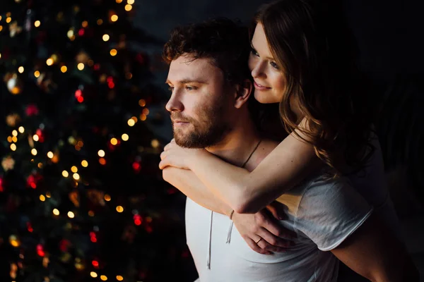 Çift pijama Noel ağacı arka plan üzerinde — Stok fotoğraf
