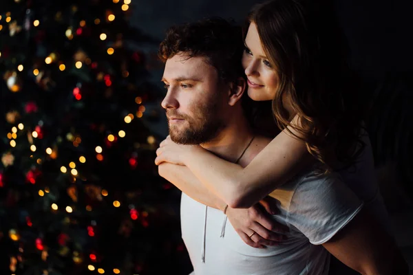 Couple en pyjama sur fond d'arbre de Noël — Photo