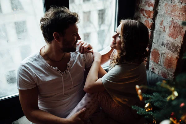 Amantes en pijama sentados en el alféizar de la ventana —  Fotos de Stock