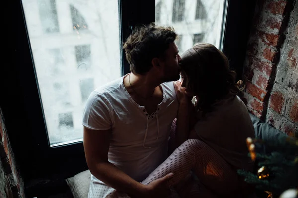 Amantes en pijama sentados en el alféizar de la ventana —  Fotos de Stock
