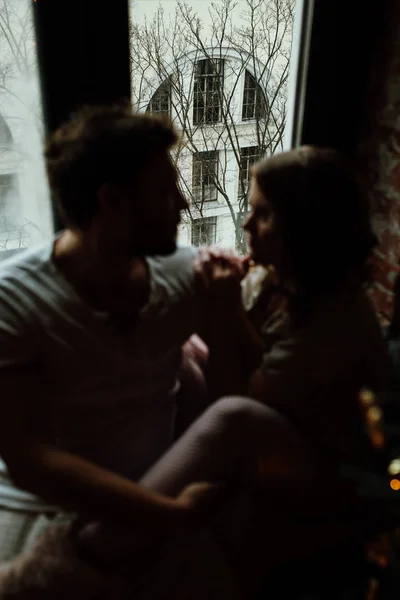 Gli amanti in pigiama seduti sul davanzale della finestra — Foto Stock