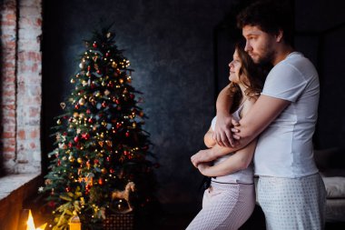 Çift pijama Noel ağacı arka plan üzerinde