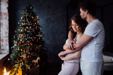 Çift pijama Noel ağacı arka plan üzerinde