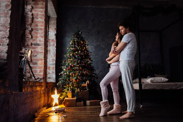 Pareja en pijama sobre fondo de árbol de Navidad —  Fotos de Stock