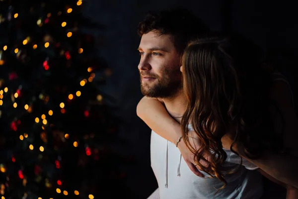 Pareja en pijama sobre fondo de árbol de Navidad —  Fotos de Stock