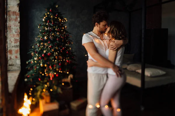 Pár karácsonyfa háttér pizsamában — Stock Fotó