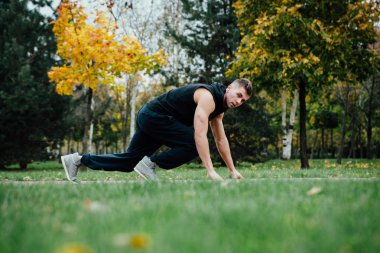 Eğitim ve sonbahar Park'ta jogging fitness adam. Başlamak için hazır. Sağlıklı yaşam tarzı