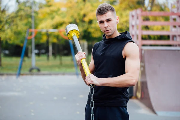 Sport man fitnesstraining buiten. met hamer en trekker banden. — Stockfoto