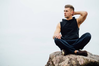 Güçlü fitness yoga adam lotus poz Okyanusu yakın kaya sahilde. Harmonik kavramı.
