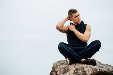 Güçlü fitness yoga adam lotus poz Okyanusu yakın kaya sahilde. Harmonik kavramı.