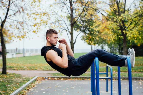Fitness man doen maag trainingen op rekstok buitenshuis — Stockfoto