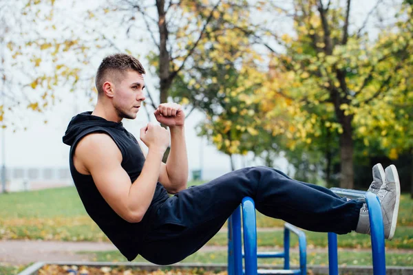 Fitness man doen maag trainingen op rekstok buitenshuis — Stockfoto