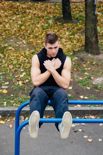 Hombre de fitness haciendo ejercicios estomacales en la barra horizontal al aire libre —  Fotos de Stock